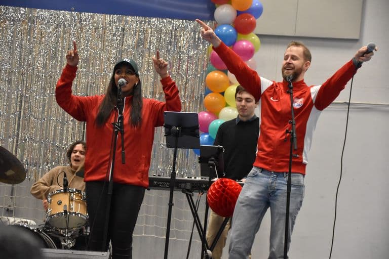 Band på scenen med to vokalister i røde jakker