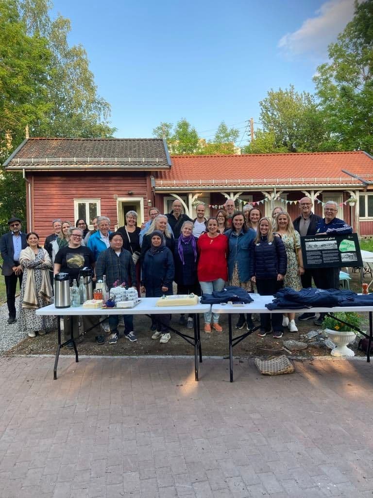 Stor gruppe naboer samlet foran nabolagshuset